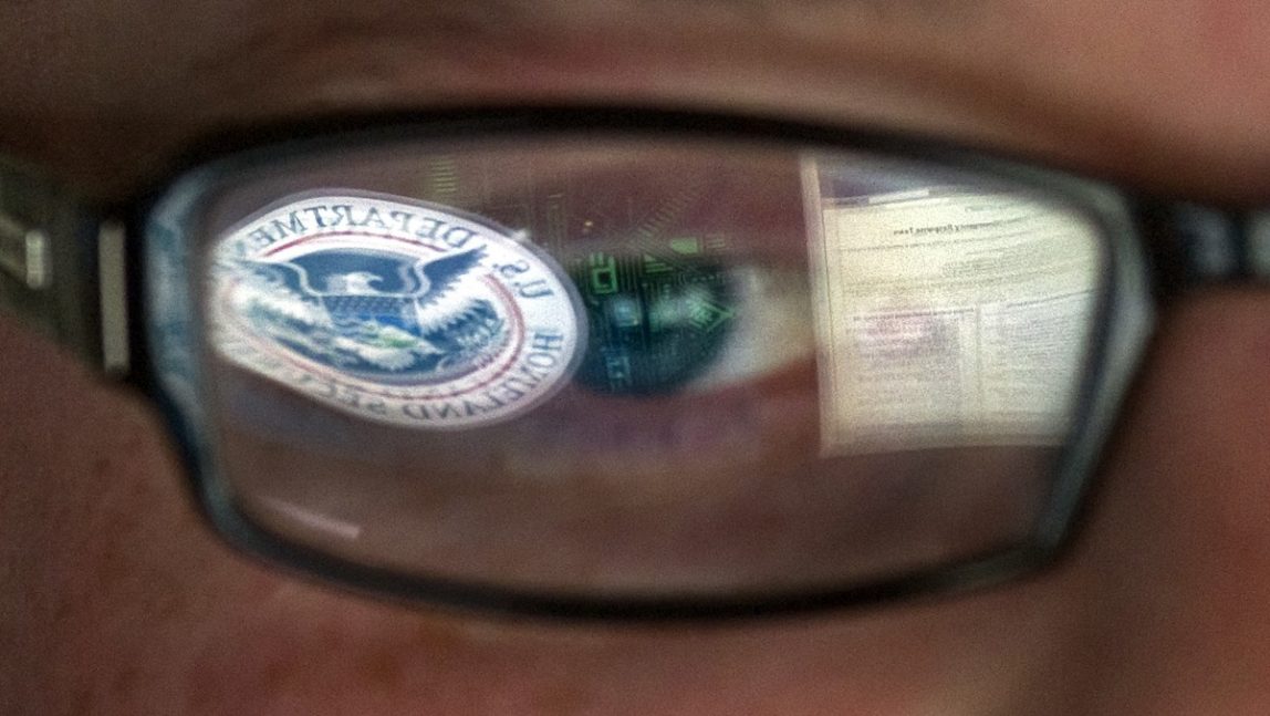 A reflection of the Department of Homeland Security logo in the eyeglasses of a cybersecurity analyst at the watch and warning center of the Department of Homeland Security's secretive cyber defense facility in Idaho Falls, Idaho.