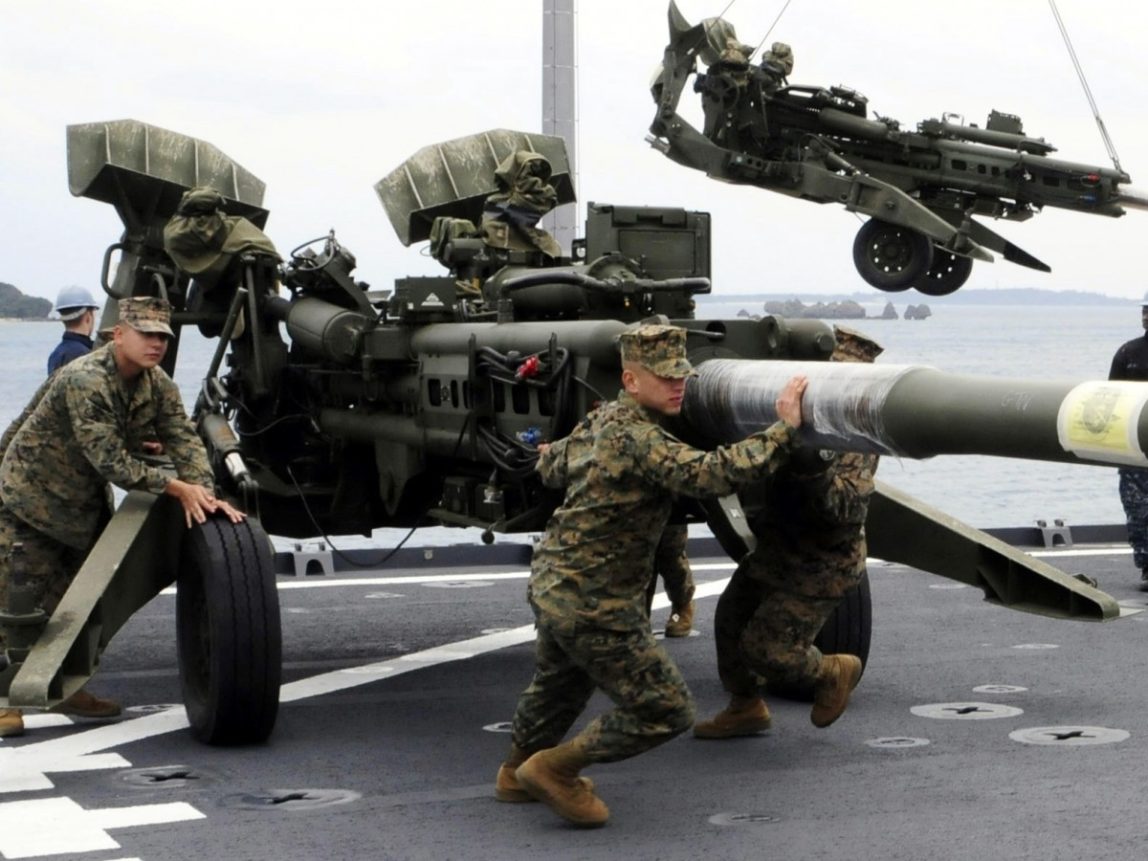 In this photo taken on Feb. 2, 2012 and released by U.S. Navy, U.S. Marines assigned to the 31st Marine Expeditionary Unit haul a 155 mm Howitzer onto the flight deck of the forward-deployed amphibious dock landing ship USS Germantown in Okinawa, Japan. (AP Photo/U.S. Navy, Mass Communication Specialist 1st Class Johnie Hickmon)
