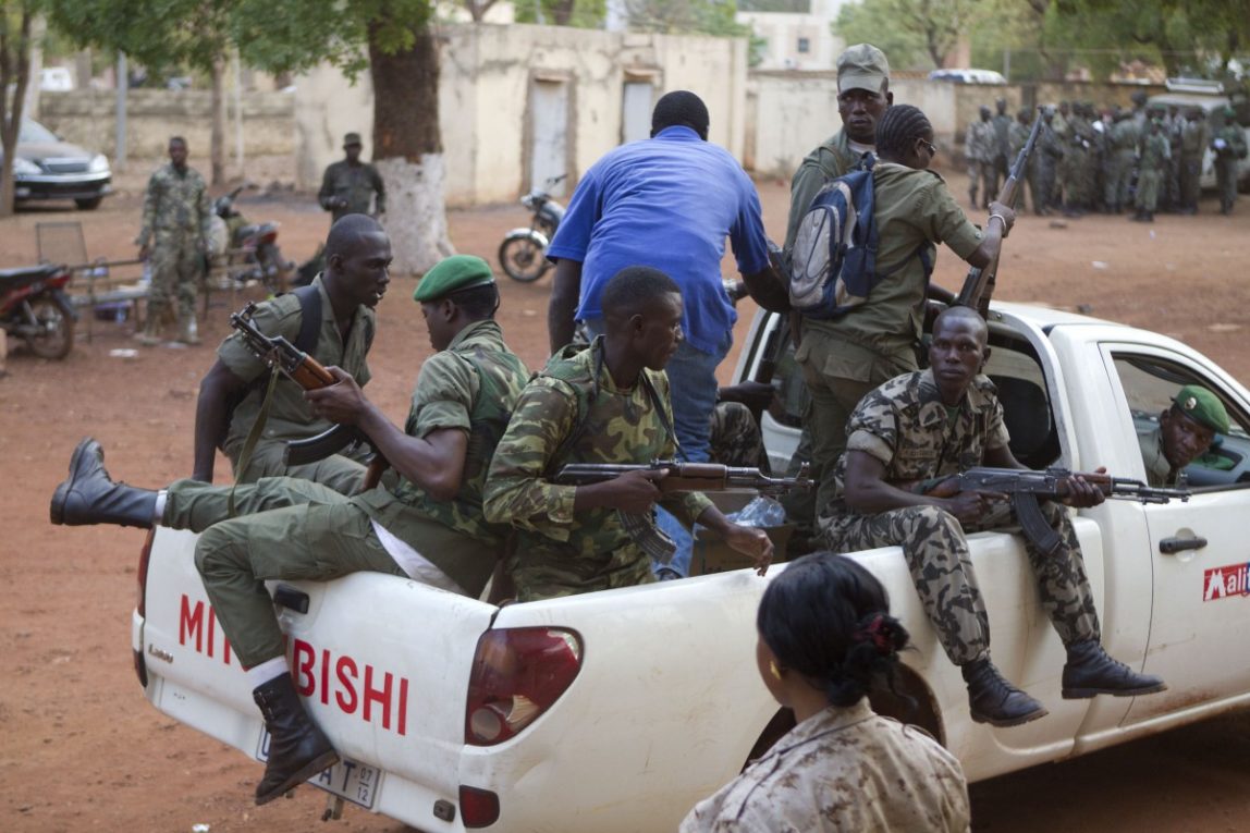 Soldiers board a truck to accompany the car of coup leader Capt. Amadou Haya Sanogo as he travels between locations at the military base where he has his headquarters, in Kati, outside Bamako, Mali Tuesday, March 27, 2012. The West African regional bloc on Tuesday suspended Mali following last week's coup and said it was sending a delegation there within 24 hours in a bid to restore democracy. (AP Photo/Rebecca Blackwell)