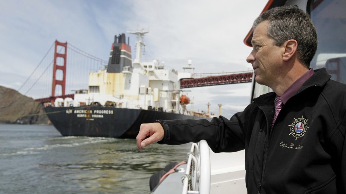 In this photo taken Wednesday April 25, 2012, Capt. Bruce A. Horton, president of the San Francisco Bar Pilots, watches as a tanker passes beneath the Golden Gate Bridge in San Francisco. Since the days of Mark Twain, the pilots have had it good. Thanks to political clout and highly specialized training, this cadre of 60 ship captains has for more than a century had control over guiding oil tankers and cargo ships in, out and around the San Francisco Bay. (AP Photo/Eric Risberg)