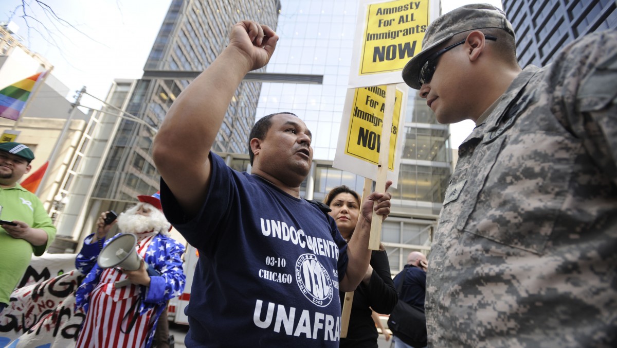 Juan Perez, left, who opposes the Tea Party, talks to Iraq veteran Army Sgt. Pete Garay right, about immigration reform during a Tea Party rally at the Daley Plaza Thursday, April 15, 2010, in Chicago. (AP Photo/Paul Beaty)