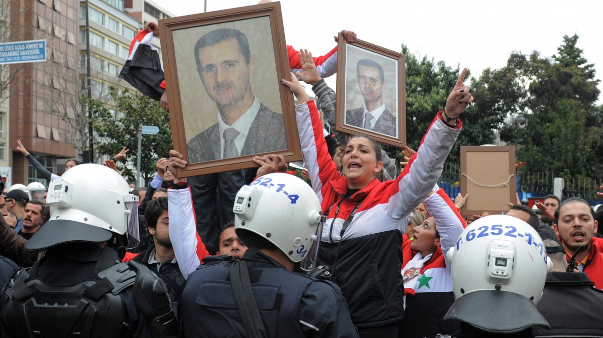 Pro-Assad Syrians demonstrate outside the meeting hall as foreign ministers from dozens of countries gather to set conditions for a new Syria, pushing for tighter sanctions and diplomatic pressure to further isolate President Bashar Assad, while urging the opposition to offer a democratic alternative to his regime, in Istanbul, Turkey, Sunday, April 1, 2012. The show of solidarity at the Friends of the Syrian People conference in Istanbul, was marred by the absence of China, Russia and Iran, key supporters of Assad who disagree with Western and Arab allies over how to stop the bloodshed. (AP Photo)