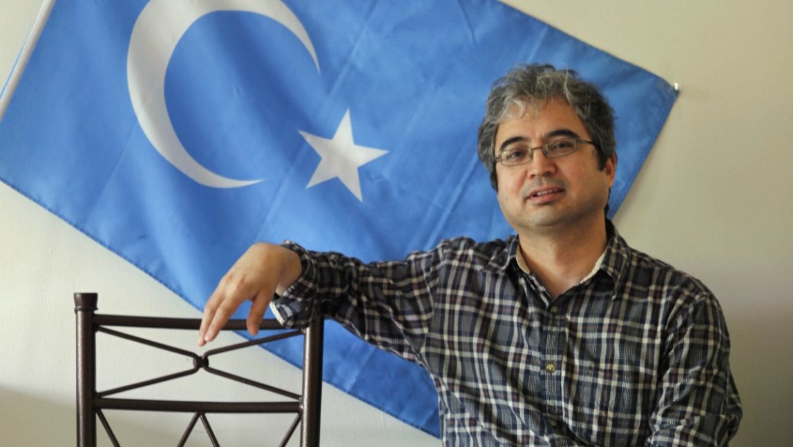 Ilshat Hassan, 47, an Uighur, sits by an Uighur flag in his apartment in Arlington, Va., Thursday, May 14, 2009. Hassan hopes that Uigher Guantanamo detainees will be released and has made plans to house two of them in an apartment that he will share. (AP Photo/Jacquelyn Martin)