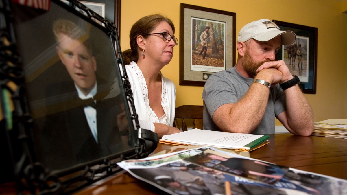 ** FILE ** In this Nov. 12, 2007 file photo, Chris Scheuerman comforts his former wife, Anne, while the couple reminisce about their son Jason, in photo, in Sanford, N.C. Three weeks after an unlicensed Army psychologist concluded Pfc. Jason Scheuerman was capable of faking mental illness to get out of combat duty, he killed himself. Scheuerman's death, the subject of an internal Army investigation exposed to The Associated Press by his family, casts light on the use by the Armed Forces of unlicensed mental health professionals to help soldiers cope with the extreme stress of combat. (AP Photo/Jonathan Fredin, File)