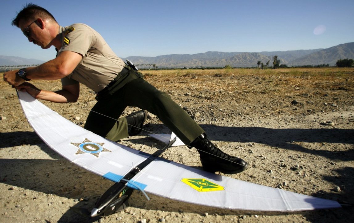 Los Angeles County Sheriff's Deputy Troy Sella assembles the Unmanned Aerial Vehicle, SkySeer, an autonomous drone aircraft used for surveillance and reconnaissance for the military and law enforcement, during a demonstration Friday, June 16, 2006, in Redlands, Calif. In the months ahead, the Los Angeles County Sheriff's Department will test an unmanned, remote-controlled surveillance plane. (AP Photo/Damian Dovarganes)