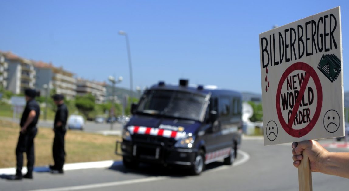 An activist protests near the meeting place for the conference of the Bilderberg Group meeting in Sitges, Spain, Thursday, June 3, 2010. The Bilderberg Group is an unofficial conference of around 130 invitation-only guests who are insiders in politics, banking, business, military and the media. The group's meetings are held in secret and are closed to the public. (AP Photo/Manu Fernandez)