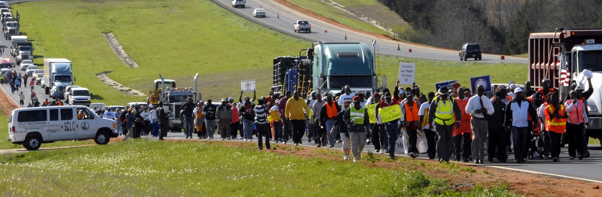 Marchers travel along Highway 80 East during the Selma Voting Rights March re-enactment Tuesday, March 6, 2012, near White Hall, Ala. (AP Photo/Julie Bennett)
