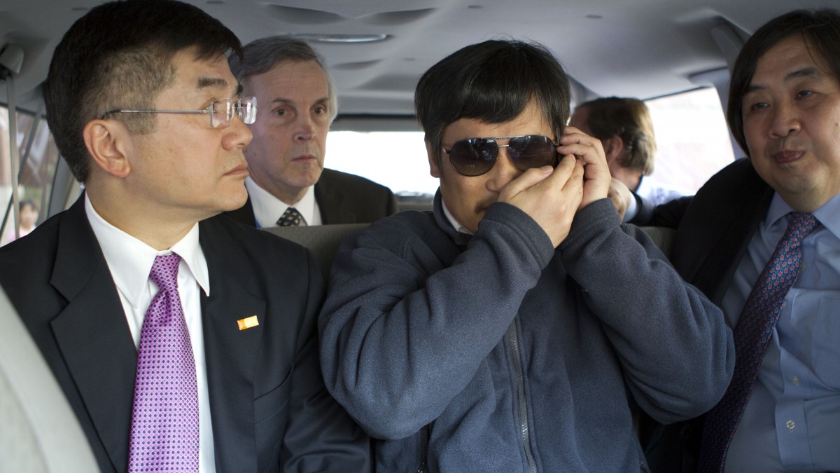 In this photo released by the US Embassy Beijing Press Office, blind lawyer Chen Guangcheng, center, accompanied by U.S. ambassador to China, Gary Locke, left, talks on a cell phone in a car en route from the U.S. Embassy to a hospital in Beijing, Wednesday, May 2, 2012. At second left is language attache James Brown and at right is U.S. State Department legal advisor Harold Koh. (AP Photo/U.S. Embassy Beijing Press Office, HO)