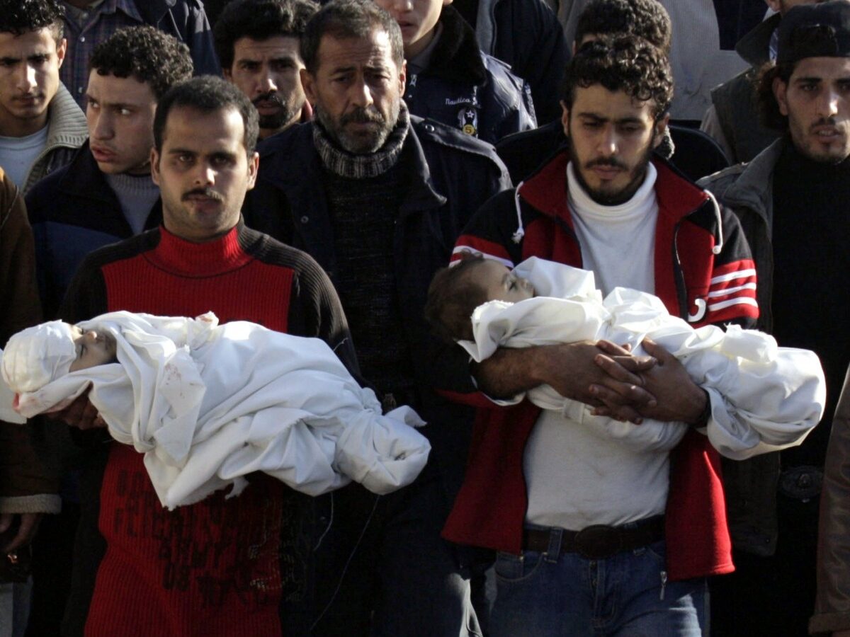 In this Monday, Jan. 5, 2009 file photo Palestinians carry the bodies of three toddlers Ahmed, Mohamed, and Issa Samouni, who according to Palestinian medical sources were killed in an Israeli strike, during their funeral in Gaza City. (AP Photo/Hatem Moussa, File)