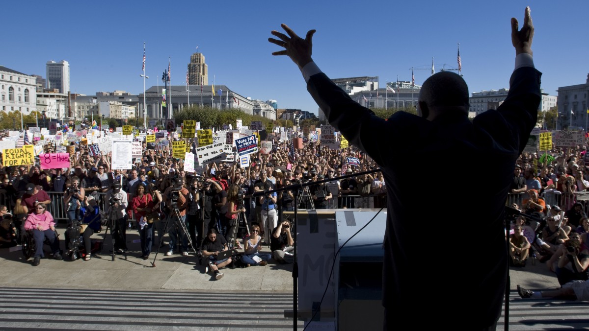Rev. Amos Brown, a national board member of the NAACP, raises his hands as he speaks to a large crowd of supporters of same-sex marriage, as they cheer in front of San Francisco City Hall on Saturday. (AP Photo/Darryl Bush)