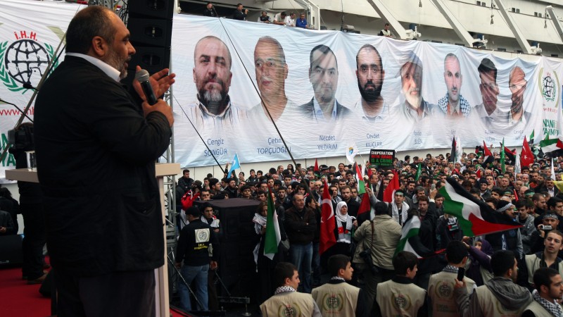 People listen to Bulent Yildirim, head of pro-Islaic group of IHH that organized the Gaza Flotilla, by a banner depicting the faces of the nine men killed, displayed on the Mavi Marmara ship. (AP Photo/Burhan Ozbilici)