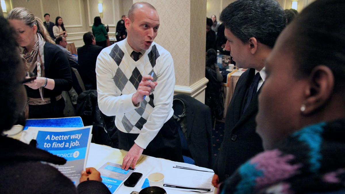 Jason Weinstein, an account manager for Workforce1 Healthcare, discusses job opportunities with attendees at JobEXPO's job fair on Wednesday, Jan. 25, 2012 in New York. (AP Photo/Bebeto Matthews)