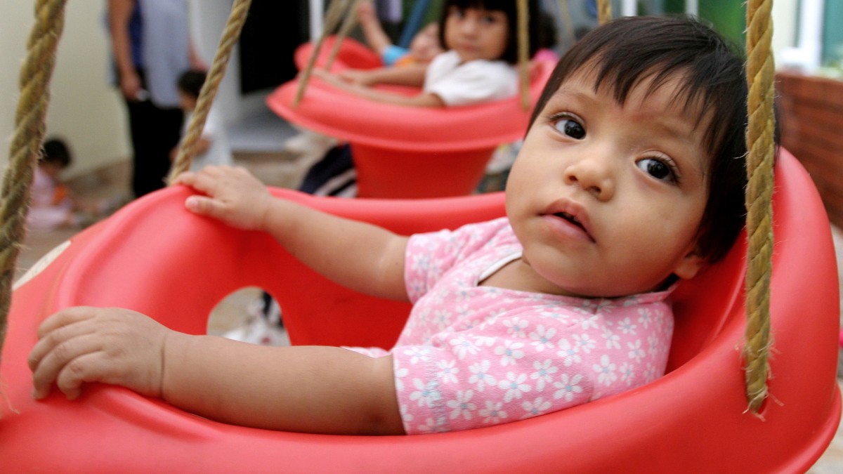 In this June 12, 2006 file photo, children sit in swings in Guatemala City, Guatemala. (AP Photo/Alexandre Meneghini, File)