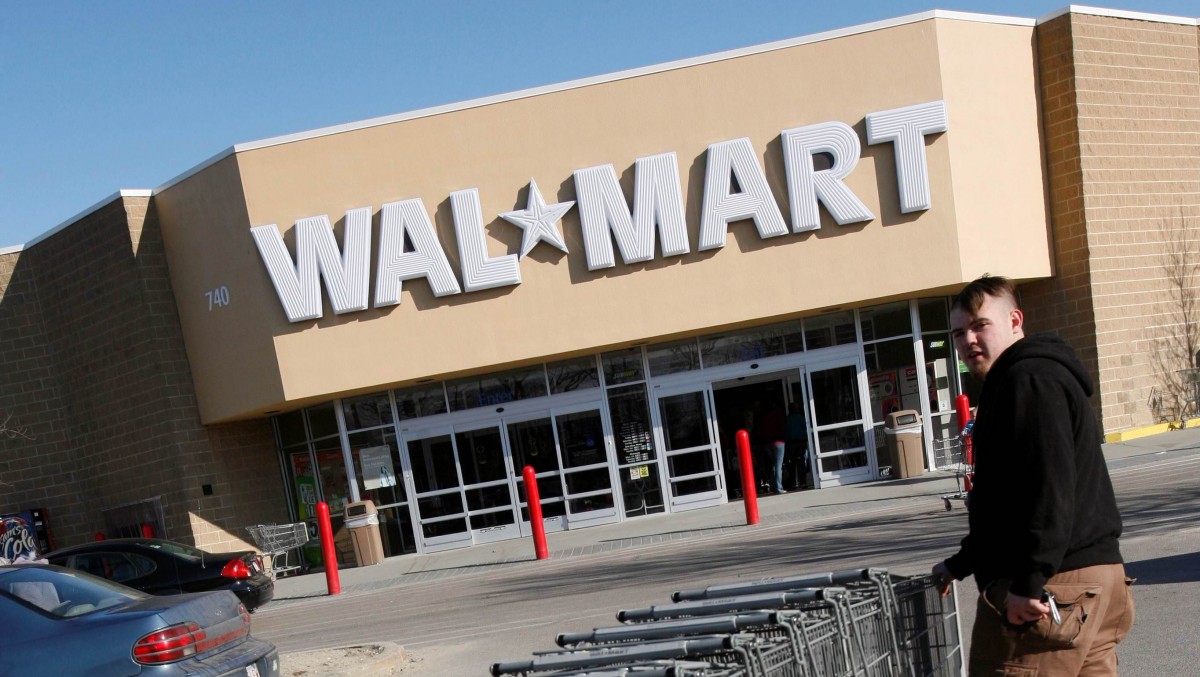 In this Monday, Feb. 16, 2009 file photo Wal-Mart employee Sean Blais moves shopping carts in the parking lot of the Wal-Mart store in Weymouth, Mass. (AP Photo/Michael Dwyer)