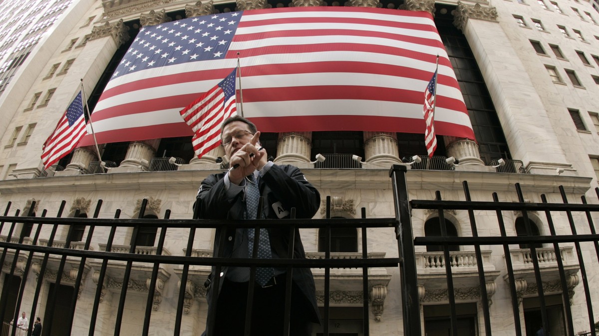 A New York Stock Exchange worker talks on his cell phone outside the exchange an hour before the closing bell in New York. (AP Photo/Julie Jacobson)