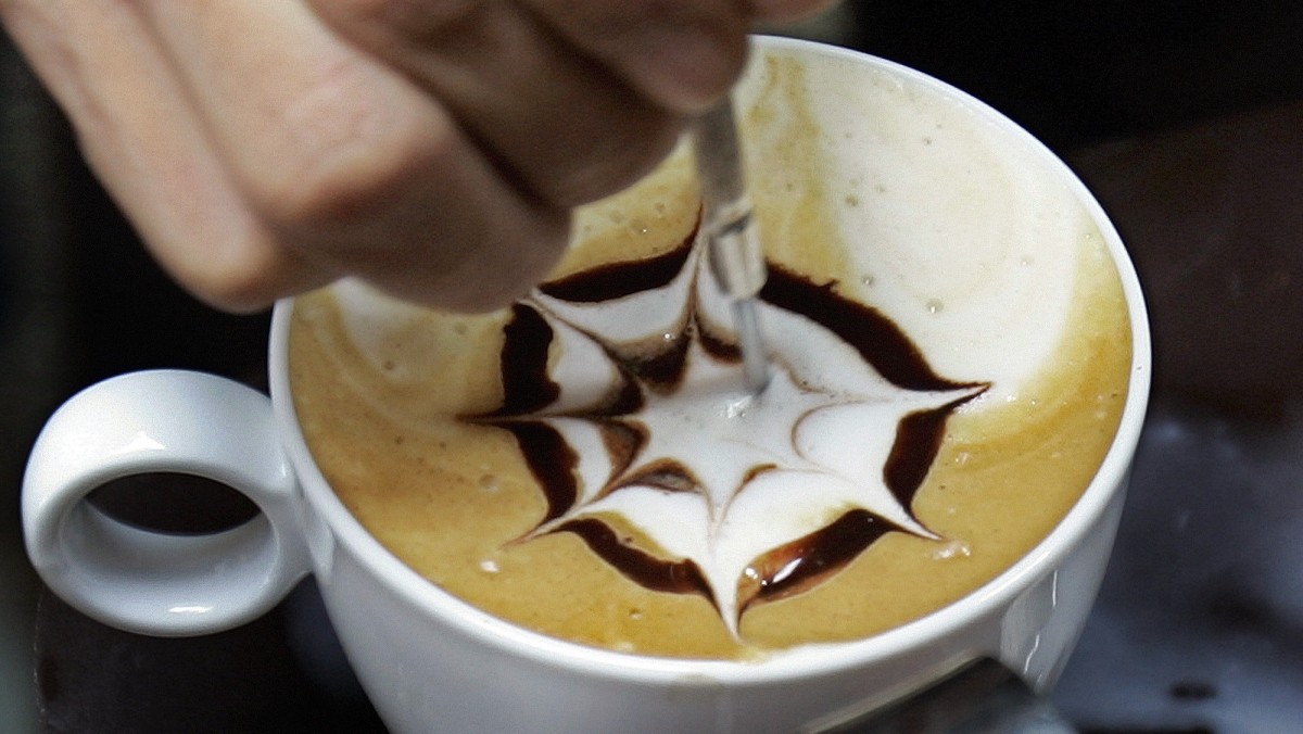 A Trung Nguyen Coffee staff member demonstrates how to create art work on a cup of coffee using milk and chocolate at their booth at the Coffee Culture Week expo in Hanoi,Vietnam, Friday, Nov. 30, 2007. The expo is aimed at honoring Vietnamese coffee and promoting coffee sales inside the country. The event will be held until Dec. 2 in Hanoi and then will moved to Ho Chi Minh City Dec. 13-16. (AP Photo/Chitose Suzuki)