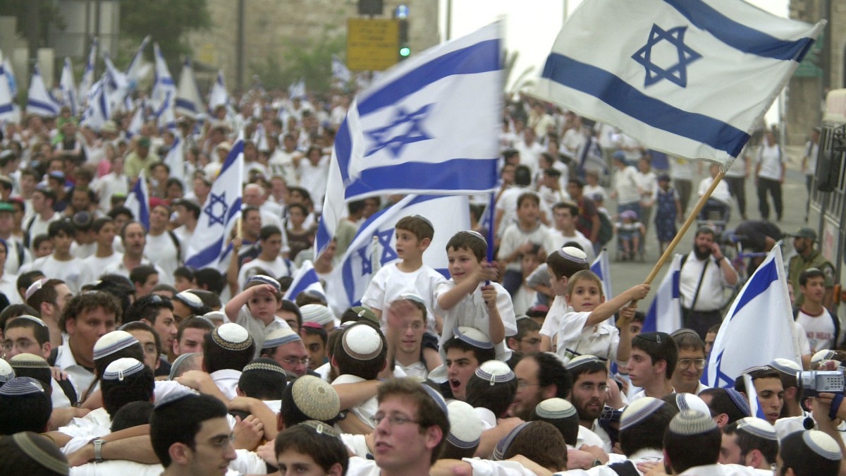 Thousands of religious Israelis wave Israeli flags during a march around Jerusalem's Old City on Jerusalem Day, Thursday, May 29, 2003. Jerusalem Day, the 36th anniversary of the unification of Jerusalem in the 1967 Mideast War, is marked by Israelis. (AP Photo/ Muhammed Muheisen)