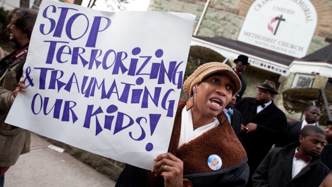 Rosemarie Melbourne, of the Bronx, holds a sign in protest of police brutality after the funeral services of Ramarley Graham, 18, who was shot in his home by a police officer who mistakenly thought he had a gun, Saturday, Feb. 18, 2012, in the Bronx borough of New York. Civil rights activist Al Sharpton spoke during the service and pledged that Graham will not be forgotten and called the Feb. 2 killing unjust. (AP Photo/John Minchillo)