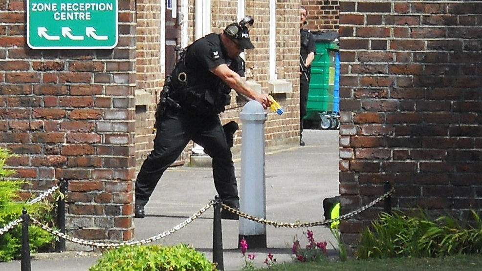 A police officer uses a taser on a person who is laying on the ground. (Photo by David Holt)