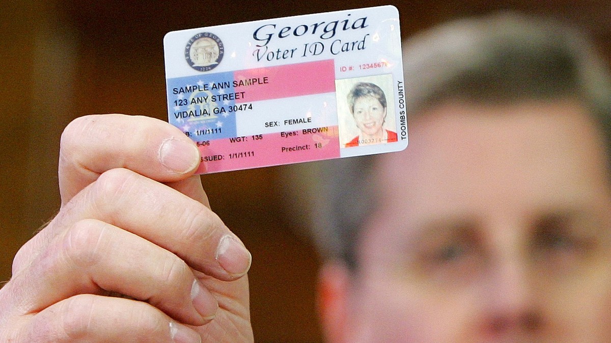 Georgia Gov. Sonny Perdue holds up a sample Voter ID after signing the bill into law at the Capitol in Atlanta, Jan. 26, 2006. Sen. Cecil Staton, R-Macon, sponsor of the Voter ID legislation in the Senate is seen in the background. (AP Photo/Ric Feld)