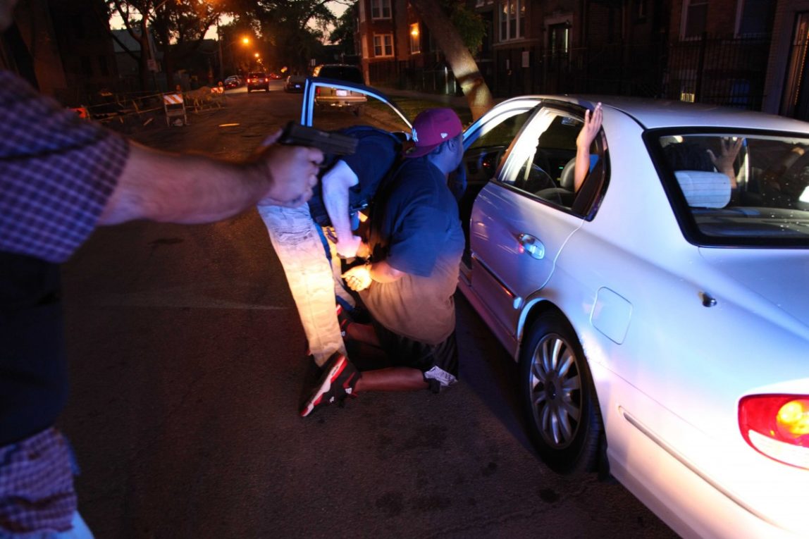 In a June 9, 2012 photo, on Chicago's West side, a high speed pursuit following four suspected gang members ended with the Chicago Police gang unit questioning and arresting one of them on an outstanding warrant. (AP Photo/Robert Ray)