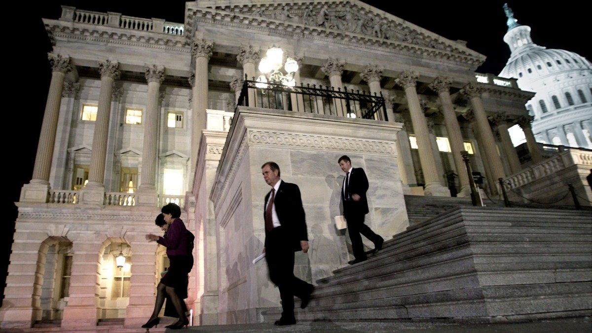 In this Feb. 18, 2011, file photo Congressmen leave the House of Representatives as they work throughout the night on a federal spending bill on Capitol Hill in Washington. (AP Photo/J. Scott Applewhite, File)