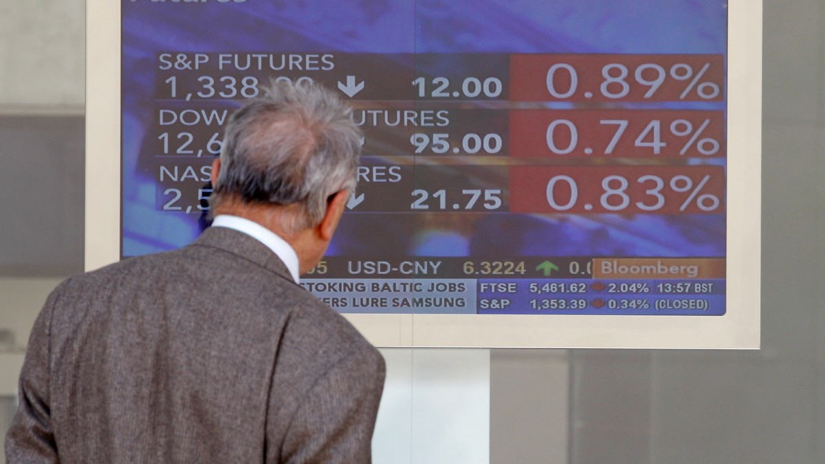 A man checks a stock exchange monitor in Milan, Italy, Monday, May 14, 2012. (AP Photo/Antonio Calanni)