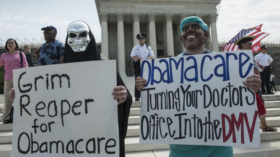 Two unidentified people hold signs on the steps of the U.S. Supreme Court in Washington, DC, June 28, 2012. (Mannie Garcia / MintPress News 2012)