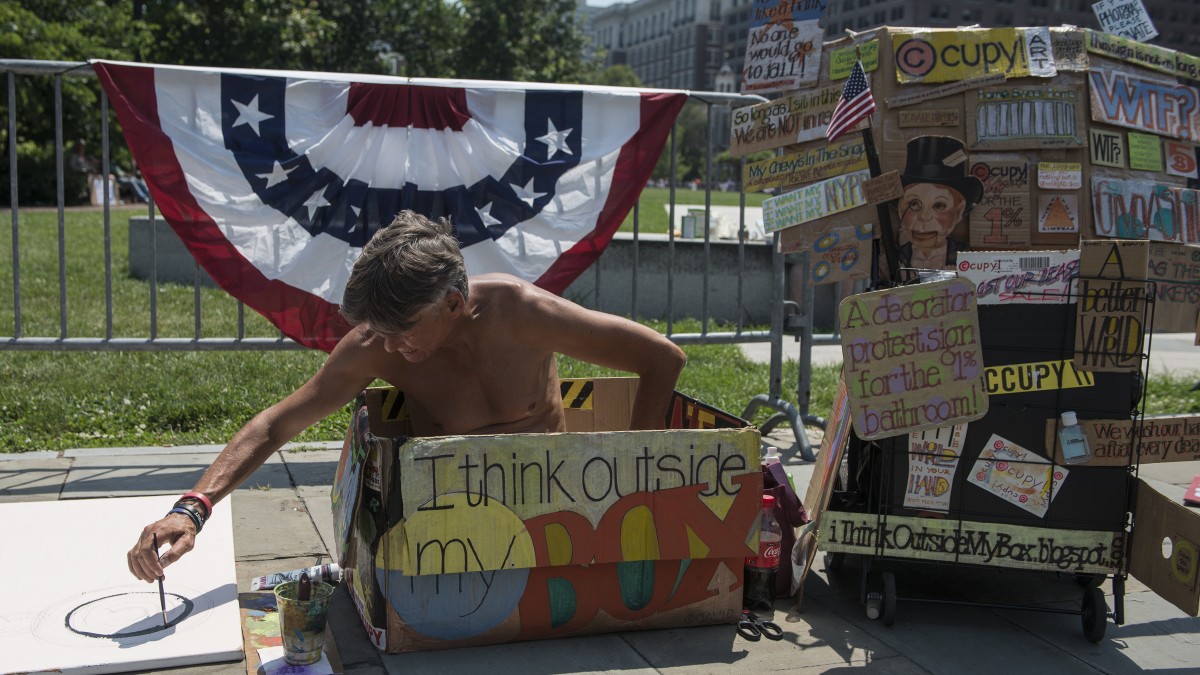 An activist sits on the streets of Philadelphia during Occupy's National Gathering. (Mannie Garcia/MintPress)