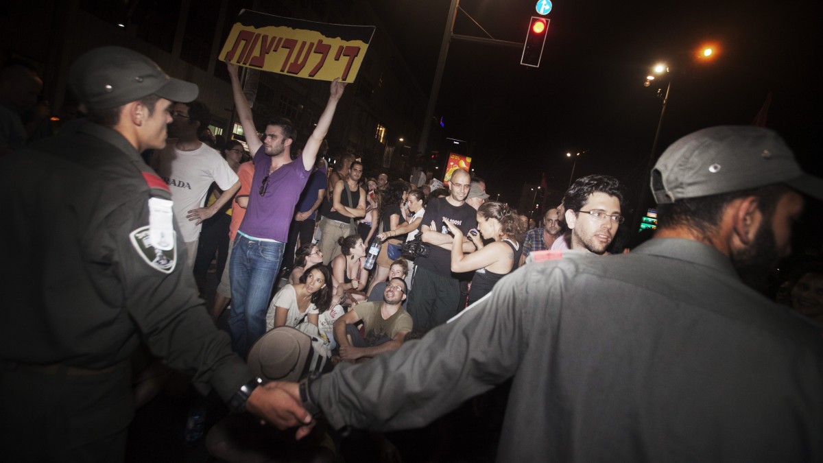 Israeli activists participate in a social protest in Tel Aviv, Israel, early Sunday, June 24, 2012. Israeli police say 85 protesters were arrested on Saturday after clashing with officers and vandalizing banks in Tel Aviv. (AP Photo/Dan Balilty)
