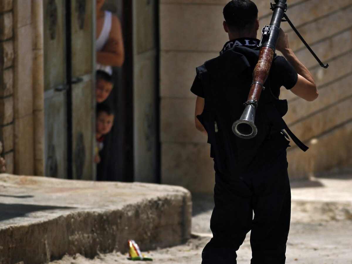 A Free Syrian Army fighter walks with a rocket launcher moments before clashing with Syrian troops near Idlib, Syria.(AP Photo/Khalil Hamra)