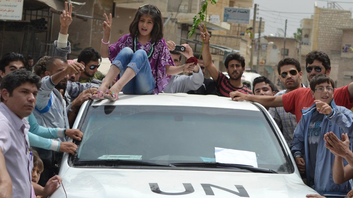 In this citizen journalism image taken on Tuesday, May 29, 2012 and provided by Edlib News Network ENN, a Syrian girl sits atop of a U.N. observers vehicle during a demonstration in Kfarnebel, Idlib province, northern Syria. U.N. Secretary-General Ban Ki-moon called on Syria on Thursday to stop its attacks, saying the U.N. observers monitoring the cease-fire were not there to watch the killing of innocent people. (AP Photo/Edlib News Network ENN)