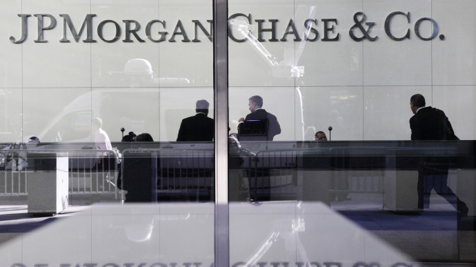 In this May 11, 2012 file photo, people stand in the lobby of JPMorgan Chase headquarters in New York. (AP Photo/Mark Lennihan, File)