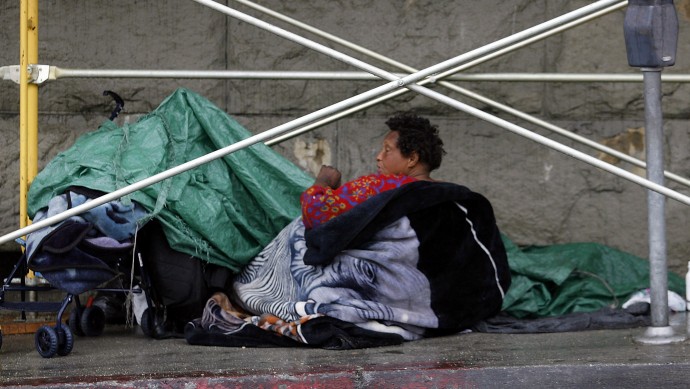 In this April 14, 2006, file photo, a homeless woman seeks shelter under construction scaffolding in the Skid Row area of downtown Los Angeles. The city of Los Angeles is violating the county health code in its Skid Row area by allowing the nation's densest population of homeless people to live on streets infested with rats, human excrement and used hypodermic needles, the Los Angeles County Department of Public Health has found, in a survey conducted through May 2012. (AP Photo/Damian Dovarganes, File)