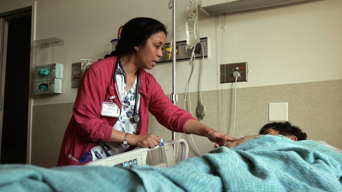 Charge nurse Eshter Marania checks on a patient at a hospital in San Francisco. (AP Photo/Jeff Chiu)