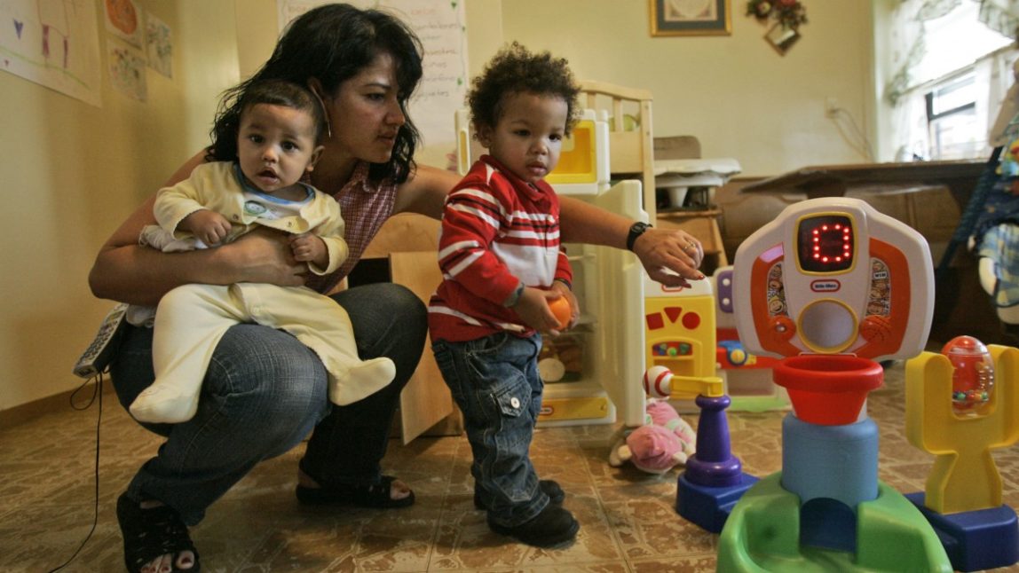 Home-based child care worker Jennie Rivera holds 5-month-old Erick while helping Christian, 1, at her apartment, Thursday, Nov. 1, 2007 in New York. (AP Photo/Mary Altaffer)