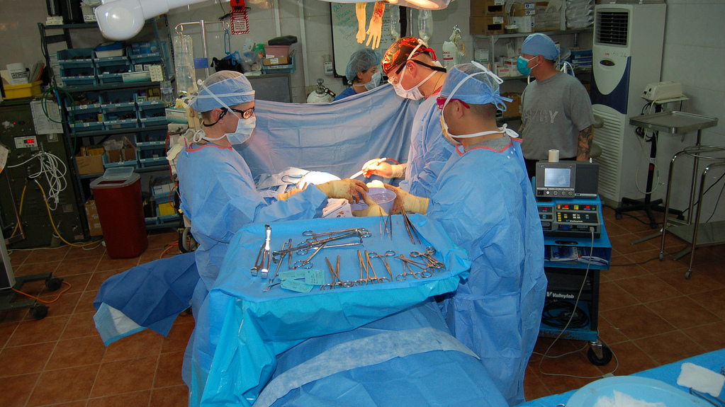 Doctors work on a patient during a surgery. (Photo by Army Medicine via Flikr)