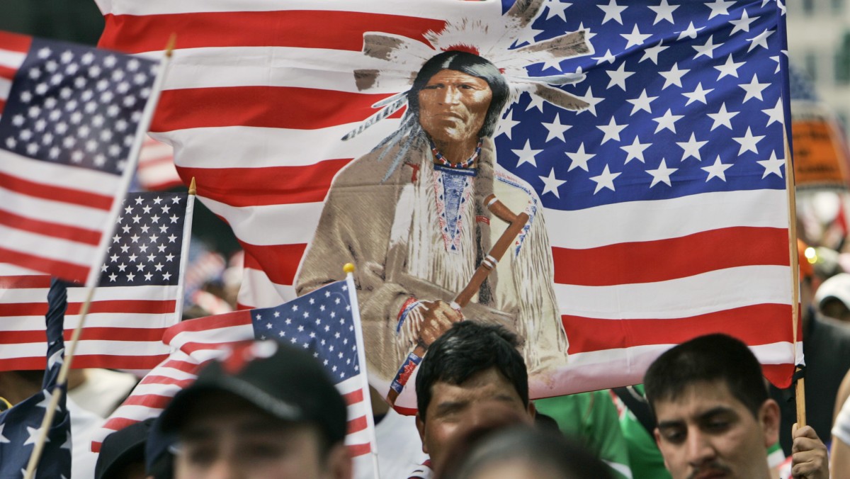 Protesters carry an U.S. flag emblazoned with an American Indian during march in Chicago, Tuesday, May 1, 2007. (AP Photo/Nam Y. Huh)