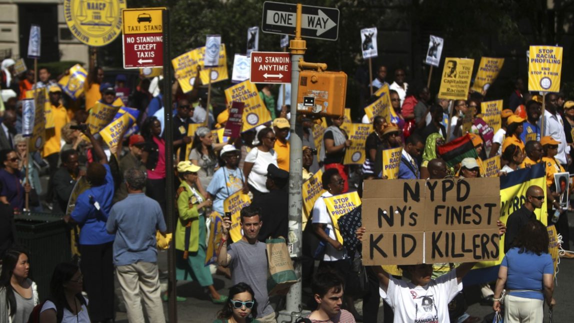 Demonstrators hold signs during a silent march to end the "stop-and-frisk" program in New York, Sunday, June 17, 2012. (AP Photo/Seth Wenig)