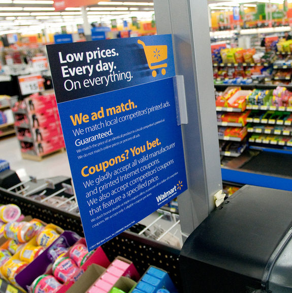 A sign is shows at a Wal-Mart checkout counter at a store. (Photo by Walmart Stores via Flikr)