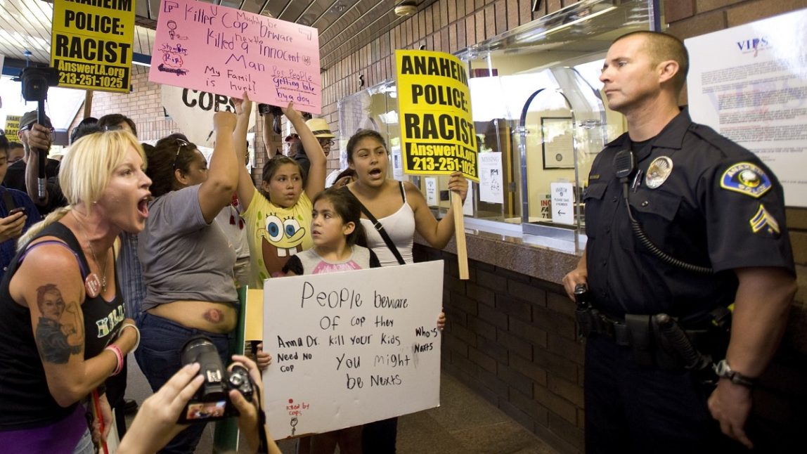 Activist Marlena Carrillo shouts at police inside the Anaheim Police Department Sunday July 22, 2012. (AP Photo/The Orange County Register, Mindy Schauer)