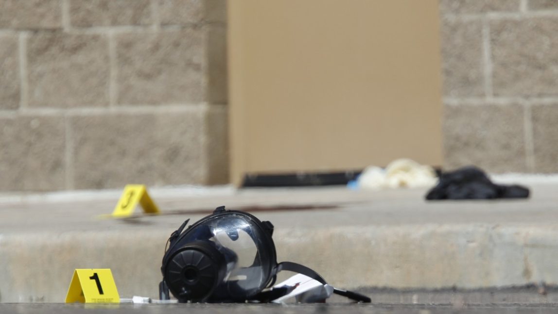 Yellow markers sit next to evidence, including a gas mask, as police investigate the scene outside the Century 16 movie theater east of the Aurora Mall in Aurora, Colo. on Friday, July 20, 2012. (AP Photo/David Zalubowski)