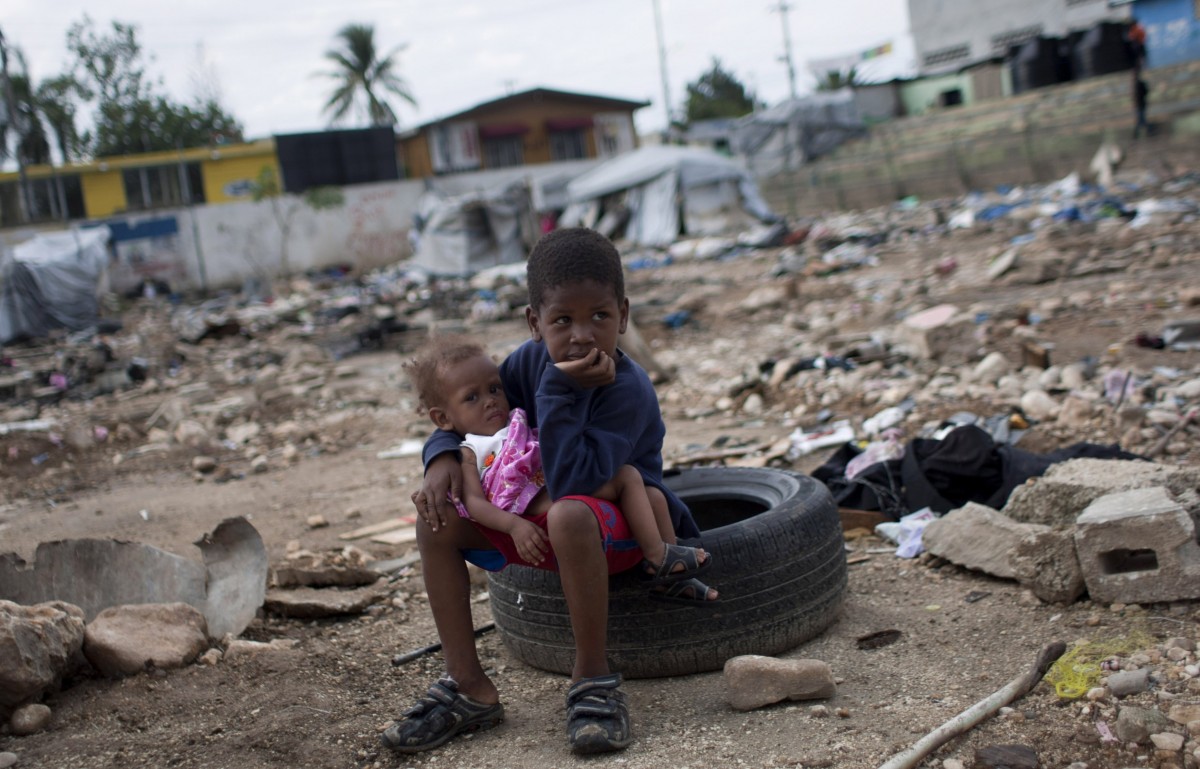 In this June 16, 2012 file photo, six-year-old Charles Kerby hold his 11-month-old sister Mikerlina Dragon at the Saint Therese camp, set up for people displaced by the 2010 earthquake, in Port-au-Prince, Haiti. (AP Photo/Dieu Nalio Chery, file)