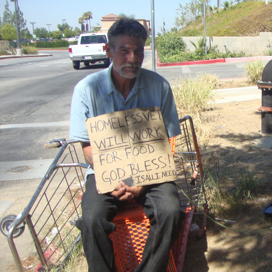 A homeless man sits on the side of the road. The VA office is being accused of misleading home operators. (Photo by Julie Jordan Scott)