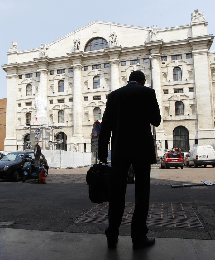 man stands in front of the stock exchange market building, in Milan, Italy, Thursday, June 28, 2012. Italy's borrowing costs in a pair of longer-dated bond auctions have spiked up to levels seen in December when concerns over the country's public finances were particularly acute. (AP Photo/Luca Bruno)