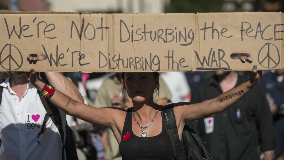 A protester holds a sign during a march through Philadelphia July 2, 2012. (Mannie Garcia/MintPress)