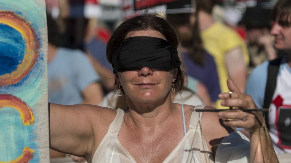 A blindfolded woman joins the Occupy National Gathering march in Philadelphia July 2, 2012. (Mannie Garcia/MintPress)