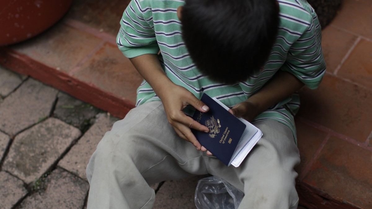 In this Tuesday, July 10, 2012 photo, a young boy examines his U.S. passport. (AP Photo/Dario Lopez-Mills)