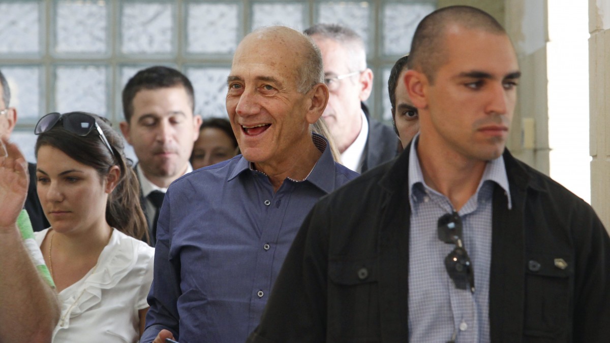 Former Israeli Prime Minister Ehud Olmert smiles at Jerusalem's District Court following a verdict hearing in his trial Tuesday, July 10, 2012. An Israeli court on Tuesday cleared Olmert of the major charges in a corruption trial that forced him from power. Olmert was found guilty of a lesser offense, and it was not clear whether that verdict could send him to jail. (AP Photo/Gali Tibbon, Pool)