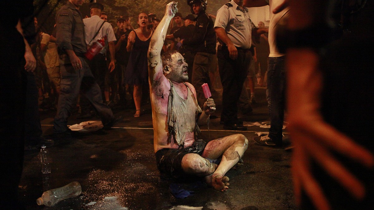 In this photograph taken on July 14, 2012, Moshe Silman, 54, holds an ice cream after he set himself on fire during a social protest in Tel Aviv, Israel. An Israeli hospital said Silman has died of his wounds Friday, July 20, 2012. (AP Photo/Shaxaf Haber)